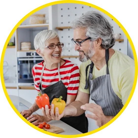 Old couple with aprons holding peppers