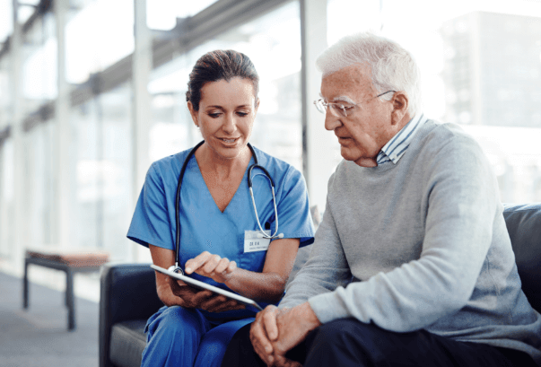 Old man sitting with medical provider discussing chart