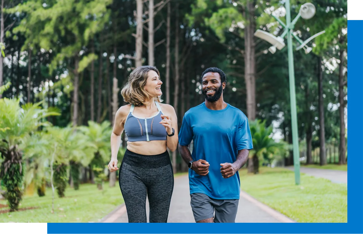 woman and man smiling at each ther while running in a park