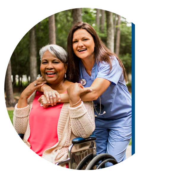 Nurse hugging woman in wheelchair.