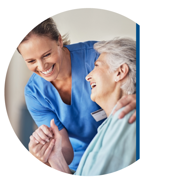 Nurse hugging woman in wheelchair.