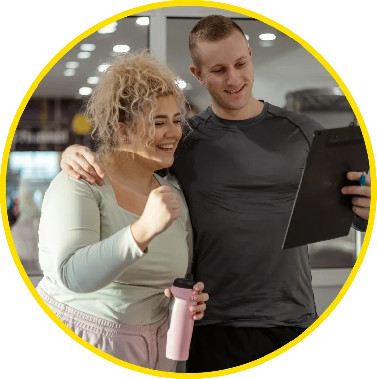 woman making progress in gym with her trainer