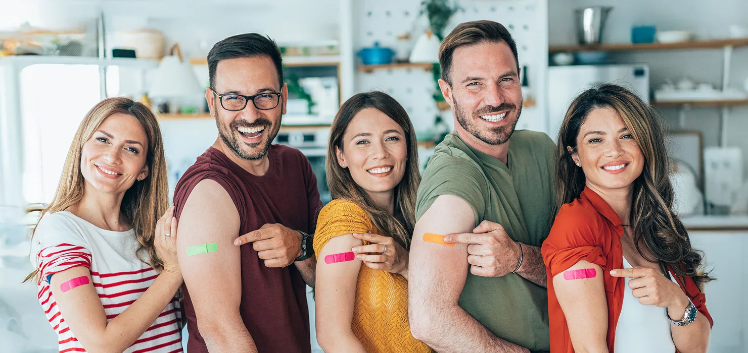 A group of people showing off their band-aids from their vaccination