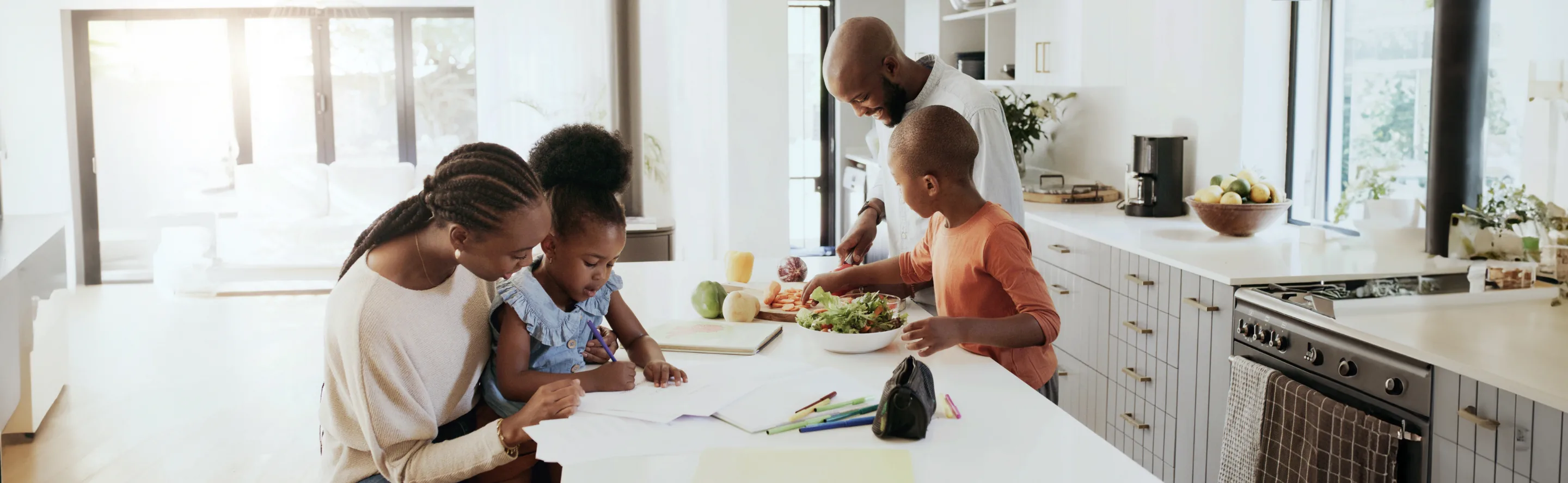 Family in kitchen having making a healthy meal while children learn to cook and study