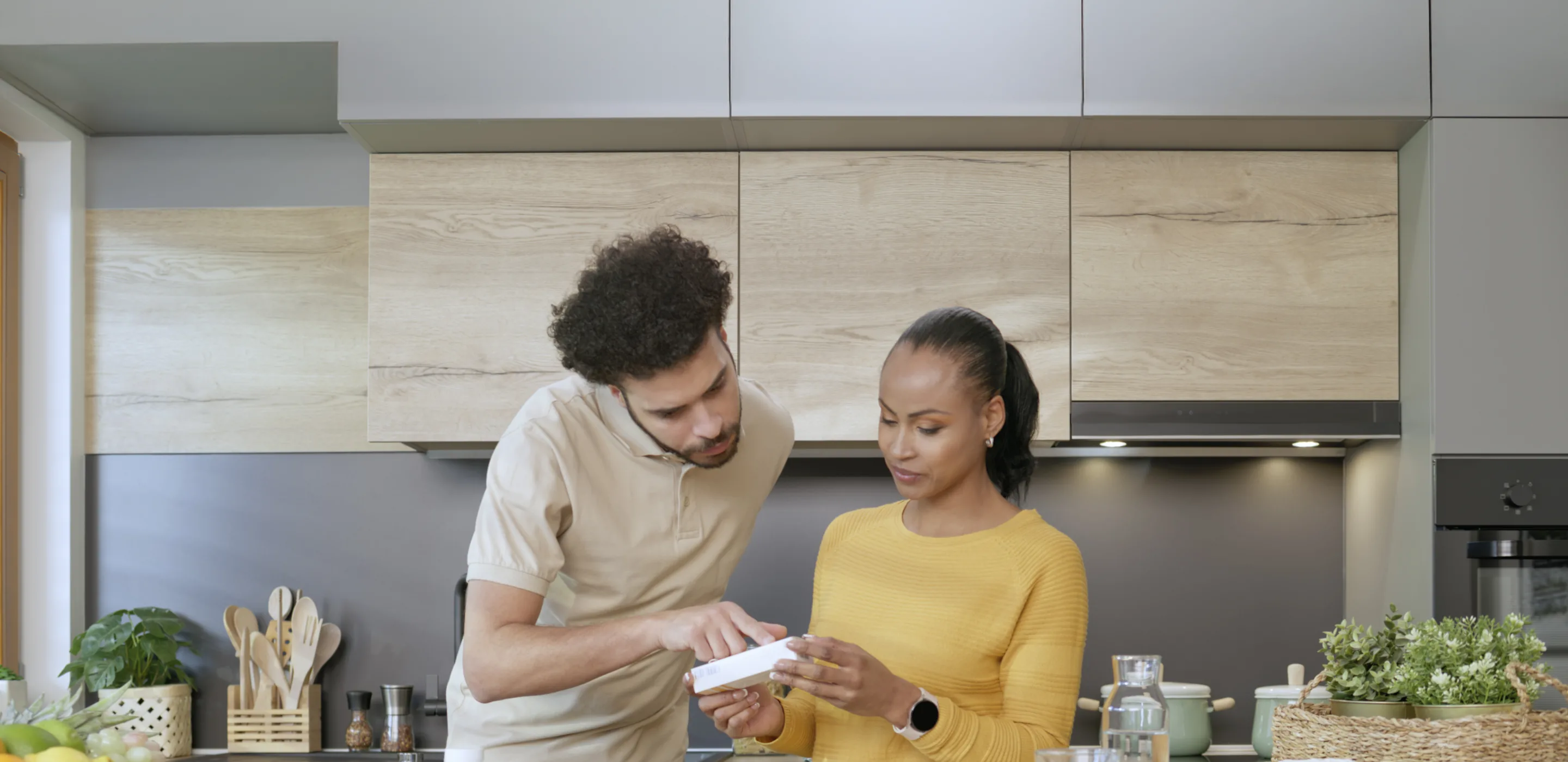 Couple in kitchen smiling while reviewing recipe with kid