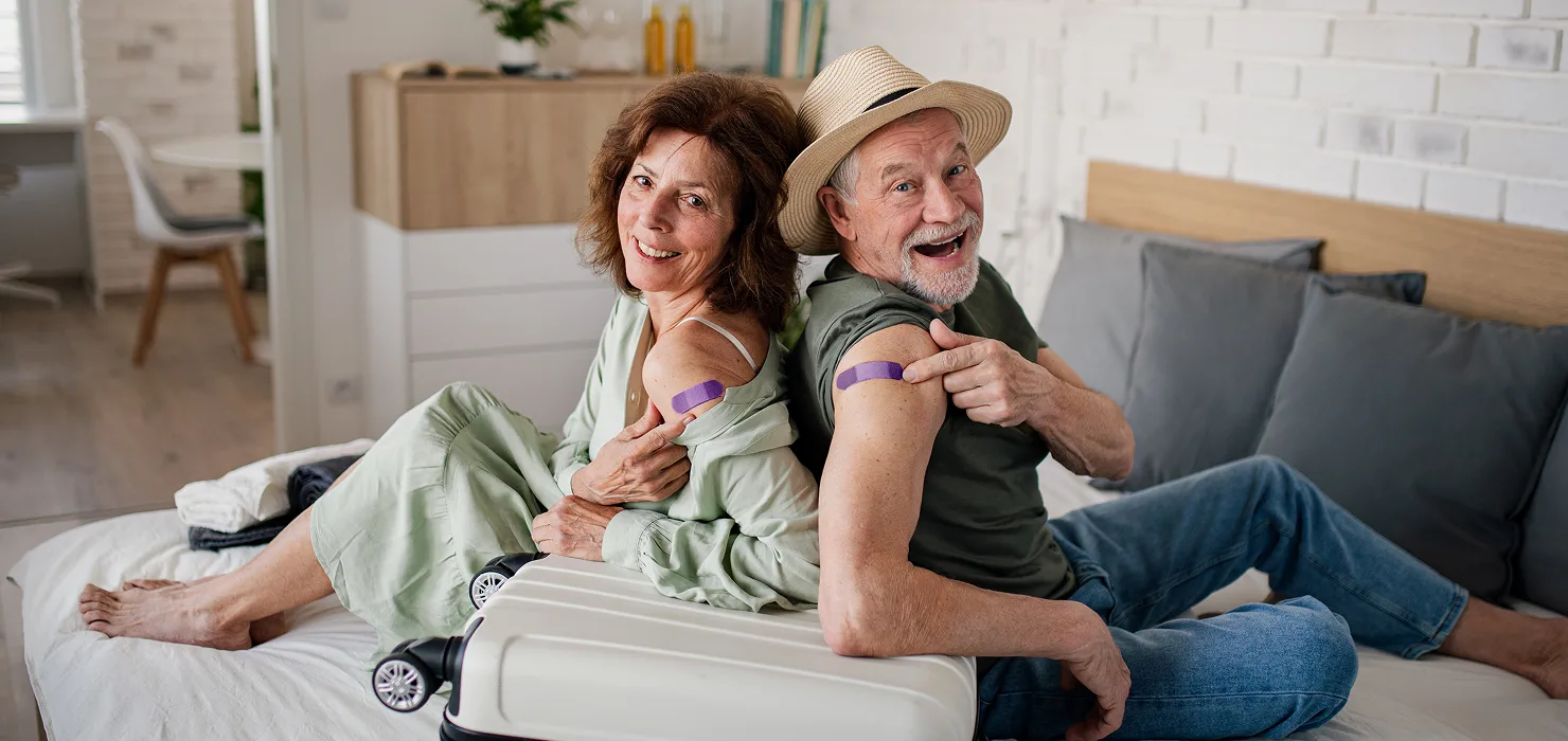 A man and woman showing off their band-aids from their vaccination