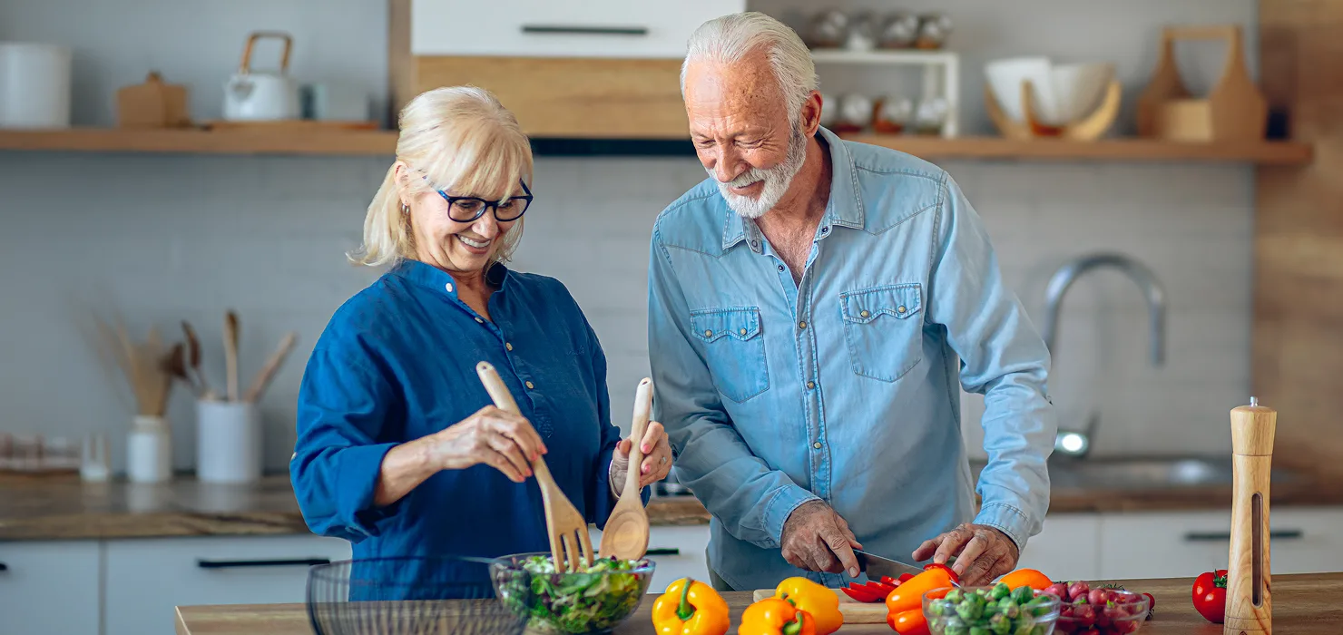 older black couple smiling & dancing at home