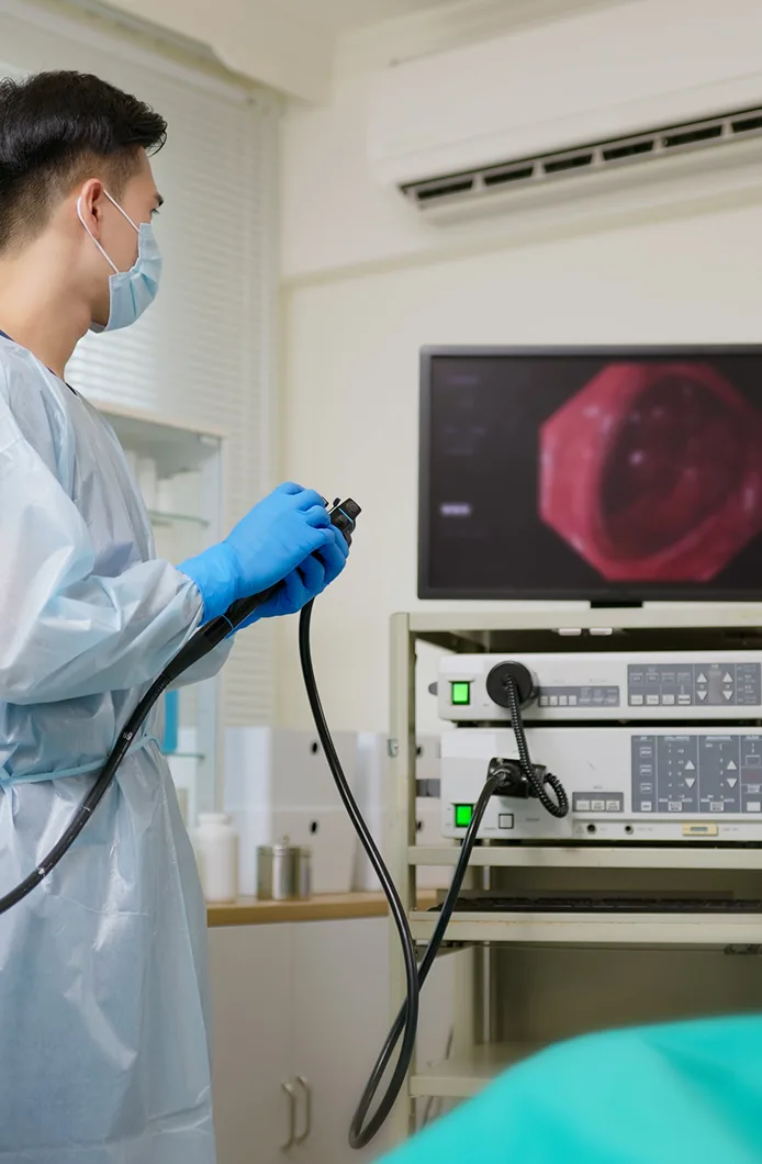Doctor performing a colonoscopy screening in an exam room