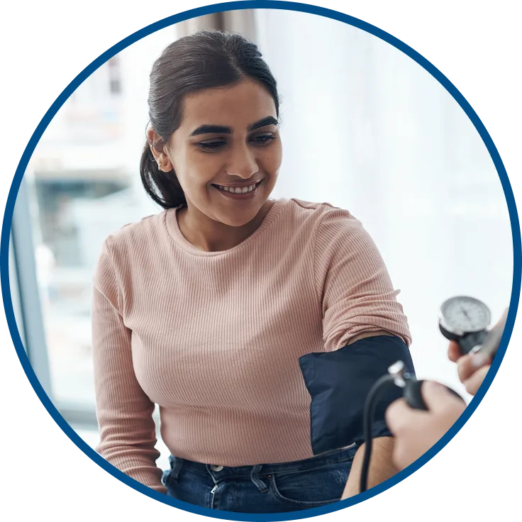 picture of a woman smiling while her blood pressure is checked in a doctor's office