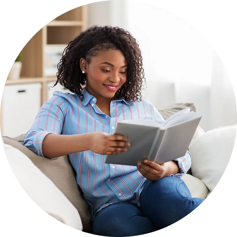 young woman smiling while she reads a book
