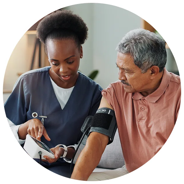 picture of a woman smiling while her blood pressure is checked in a doctor's office