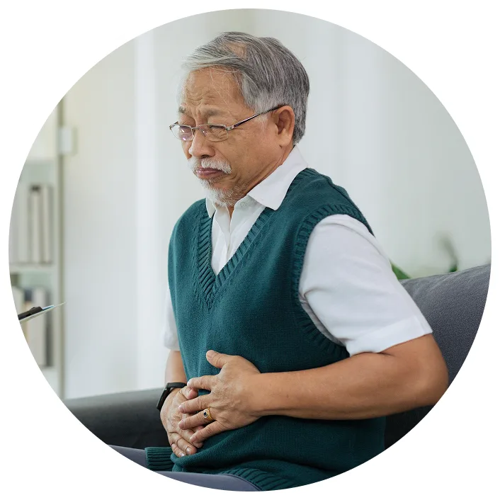 image shows an older Asian man holding his hands over his stomach as if he were feeling pain