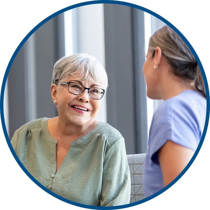 image of an older lady smiling & chatting with a healthcare provider