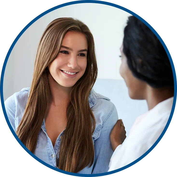image of two women smiling & talking to one another