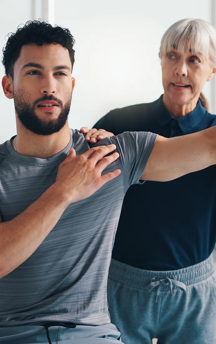 Healthcare provider checking a patient's shoulder mobility during a bone health exam