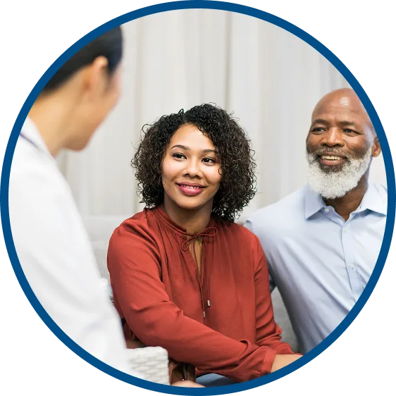 picture of a man & woman talking with their doctor in the office