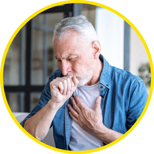 Older man coughing into his hand while holding his chest