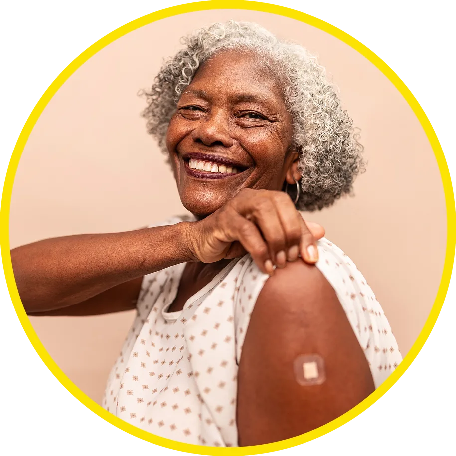 Smiling older woman showing her arm with a bandage after receiving a vaccination