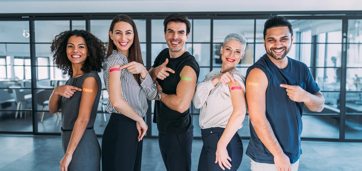 A group of people showing off their band-aids from their vaccination