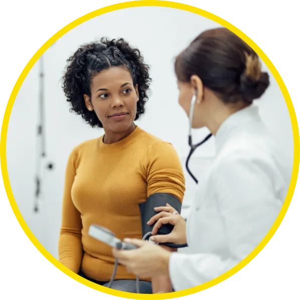 Female Patient being seen with doctor in exam room, while the female doctor listens to the stethoscope mark