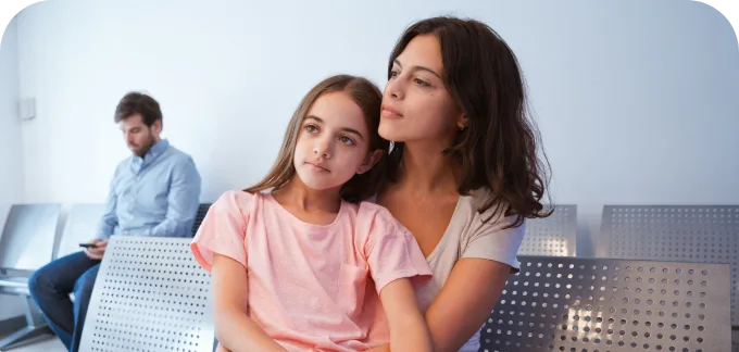 A woman and a young girl are seated on a bench, highlighting the role of social workers in fostering community relationships.